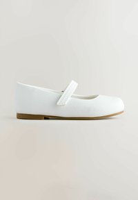 Hvid Mary Jane flad sko med afrundet tå, enkelt syet rem og lys brun sål mod en neutral baggrund.