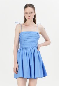 Blue dress featuring a fitted bodice with horizontal pleats, thin spaghetti straps, and a flared skirt. Fabric appears smooth and lightweight.