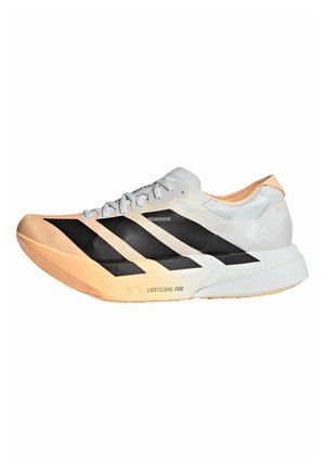 Leichter Laufschuh mit weißem Obermaterial, schwarzen Streifen, pfirsichfarbener Sohle und "Lightstrike Pro"-Branding auf der Zwischensohle.
