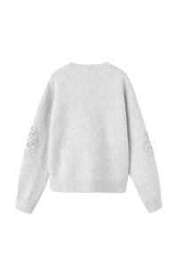 Sivi pleteni pulover s okruglim izrezom, s teksturiranim detaljima na rukavima i opuštenim krojem. Mekani materijal, rebrasti rub i manšete.