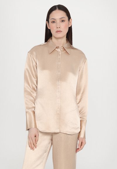 Satin blouse, light beige, featuring a button-down front, collar, and long sleeves with a smooth texture and slight sheen.