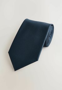 Cravate marine avec un motif texturé, une forme d'extrémité triangulaire et un tissu lisse. Style roulé, adapté à une tenue formelle.