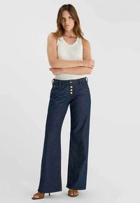 Jean évasé en denim bleu foncé avec des accents de boutons dorés, doté d'un design classique à cinq poches et d'une coupe droite jusqu'au sol.