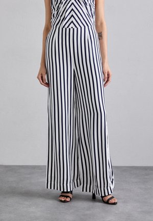 Marineblauwe en witte gestreepte broek met wijde pijpen, hoge taille en geplooide voorzijde. Gemaakt van een lichte stof met een soepele textuur.