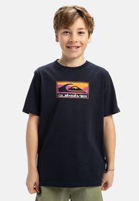 Navyfarbener Baumwoll-T-Shirt mit einem bunten Quiksilver-Logo-Graphic in der Mitte. Kurze Ärmel und Rundhalsausschnitt.