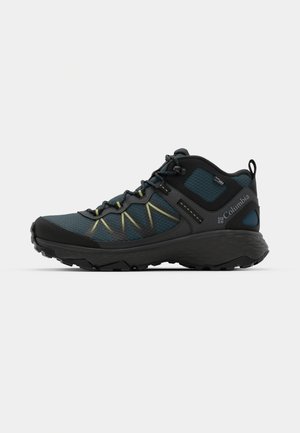 Dark blue hiking shoe with black accents, textured mesh upper, yellow stitching, and a rugged sole, suited for outdoor activities.