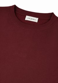 Bordeaux crewneck sweatshirt van zachte katoen, met een geborduurde tekst "Oh April" op de borst en geribde kraag en manchetten.