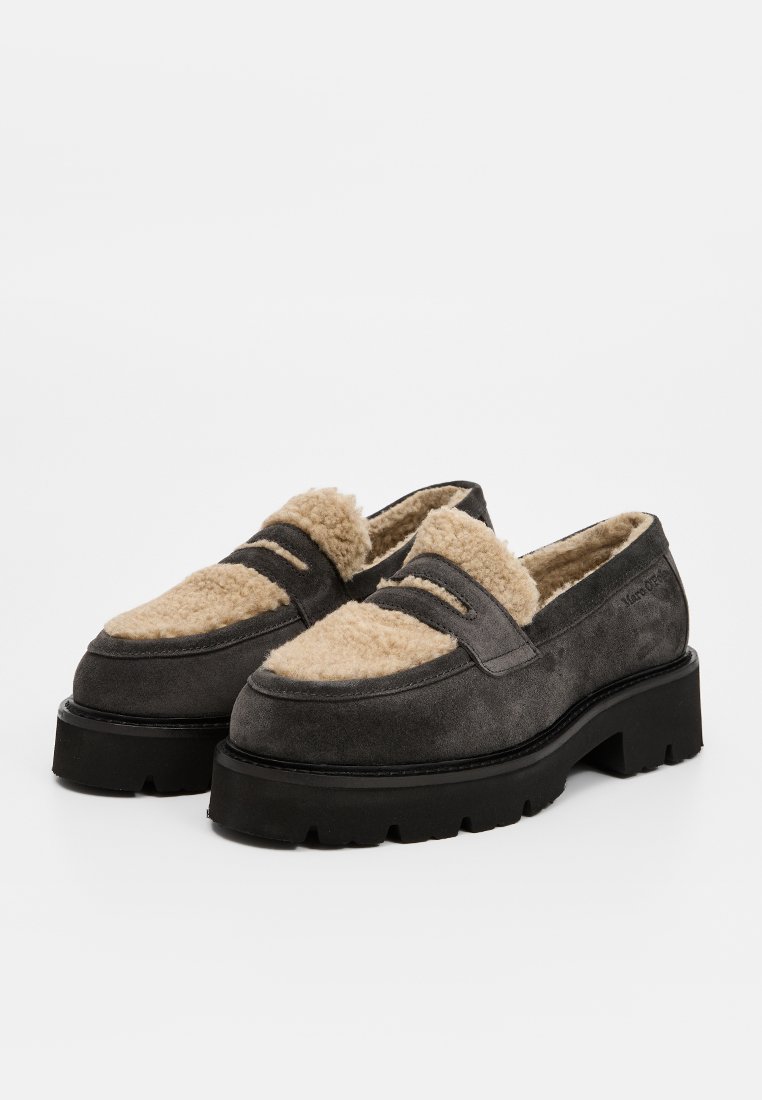 Schwarze Suede Slipper in Dunkelgrau mit einer cremefarbenen Lammfellfütterung. Versehen mit zwei dekorativen Riemen und einer massiven schwarzen Sohle mit strukturiertem Profil.