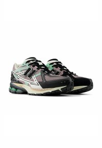Black and mint green athletic shoes with mesh upper, white and pink accents, and thick outsole featuring visible cushioning elements.
