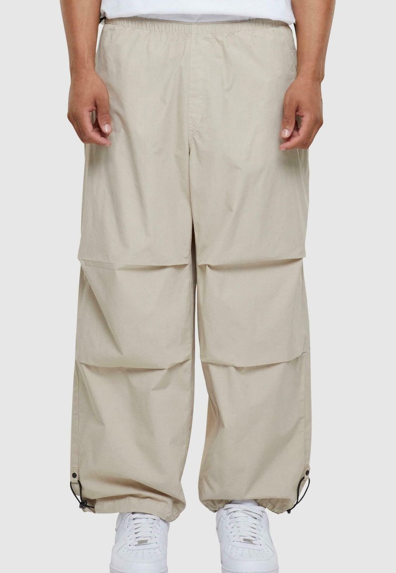 Beige cargo bukser med løst fit, elastisk talje og sidelommer. Har justerbare manchetter med snore, lavet af letvægtsstof.