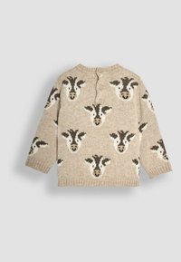 Beige Strickpullover mit einem Kuhkopf-Muster in Braun und Weiß. Runder Ausschnitt, Knopfverschluss hinten und gerippte Bündchen.