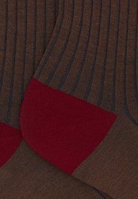 Calze a righe marroni e blu con un tallone rosso. Realizzate in tessuto lavorato a maglia, presentano una texture a coste e un design senza cuciture.