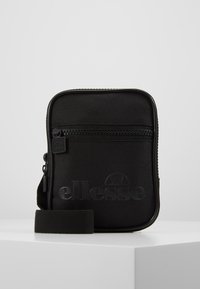Sac de crossbody Ellesse noir en tissu durable, avec un compartiment zippé, un logo embossé et une sangle ajustable. Forme rectangulaire.