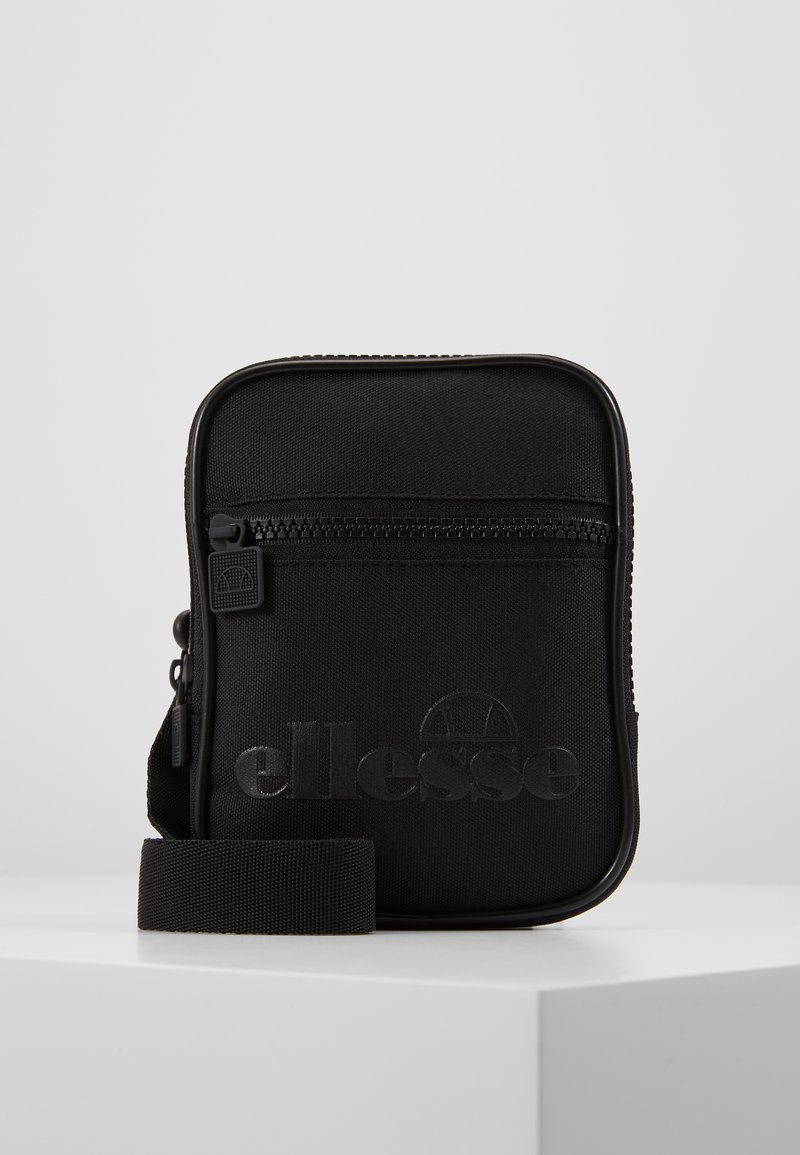 Sac de crossbody Ellesse noir en tissu durable, avec un compartiment zippé, un logo embossé et une sangle ajustable. Forme rectangulaire.