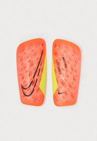 Nike Mercurial Lite Superlock skinner med et hexagonalt mønster, lyse orange og gule farver samt sorte logo akcentuer.