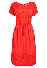Robe rouge à manches courtes, design texturé avec motifs en zigzag, taille froncée avec liens, et ourlet ajouré détaillé.