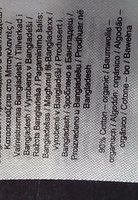 Texte sur une étiquette de tissu indiquant le Bangladesh comme pays de production et 90 % de coton biologique, écrit en plusieurs langues.