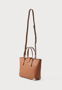 Brown leather handbag with dual handles and a detachable shoulder strap. Features a flat base with silver hardware accents.