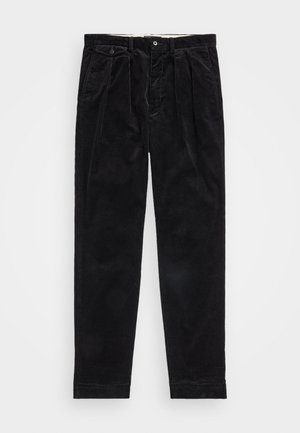 Pantalones de pana negros con frente con pliegues, dos bolsillos laterales y cierre de botón en la cintura. Textura suave con corte recto.