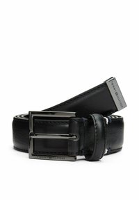 Zwarte leren riem met een glanzende zilveren gesp, met een gladde textuur en gestikte randen; voorzien van de merknaam "TOMMY HILFIGER" op het beslag.