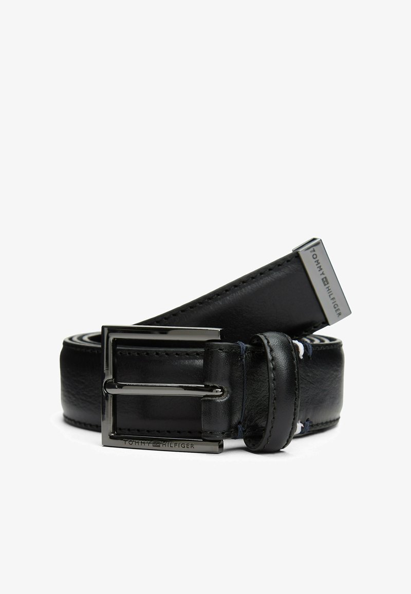 Cintura in pelle nera con una fibbia argentata lucida, caratterizzata da una texture liscia e bordi cuciti; marchiata con "TOMMY HILFIGER" sull'hardware.