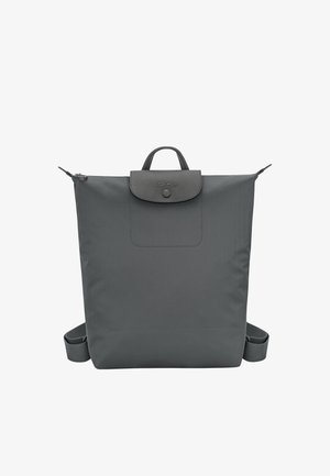 Dunkelgrauer, quadratischer Rucksack mit einem oberen Griff, Klappenverschluss mit Knopf und verstellbaren Schultergurten, die an den Seiten sichtbar sind.