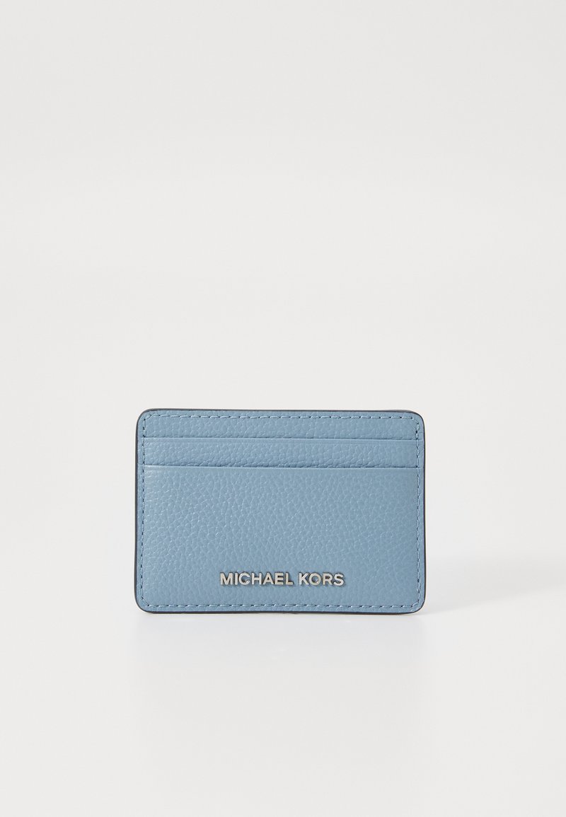 Jasnoniebieski skórzany portfel na karty o teksturowej powierzchni, z czterema slotami na karty oraz srebrnym wytłoczonym logo z przodu.