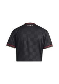 Maglia sportiva nera cropped con sottile motivo a scacchi, bordi a scacchi rossi e verdi su maniche e colletto, testo "FCBM" sulla parte alta della schiena.