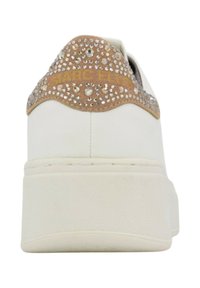 Sneaker bianco con suola spessa, con un accento in camoscio beige sul tallone decorato con strass trasparenti e testo dorato.