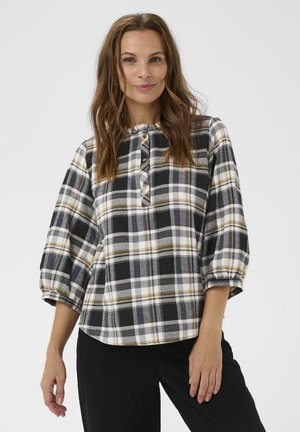 Melna, dzeltena un balta pārbaudīta krekla ar trim ceturtdaļām piedurknēm, apaļu kakla izgriezumu un koka pogām priekšpusē. Mīksta auduma tekstūra.