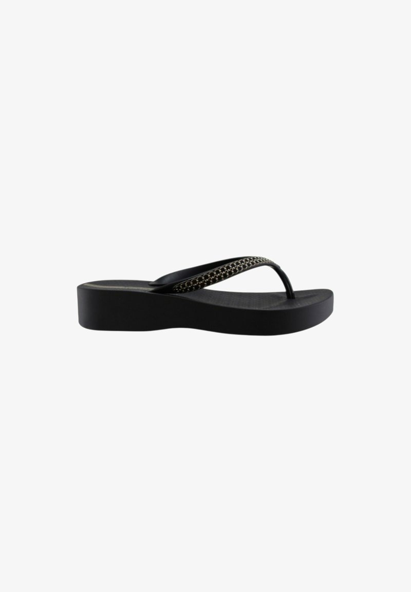 Tongs à plateforme noires avec une semelle texturée et une bride noire décorée de petits clous argentés.