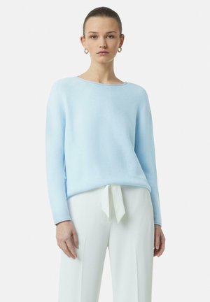 Lichts blauwe trui met een geribbelde brei-textuur, een wijd uitlopende halslijn en lange mouwen, gecombineerd met witte broek met een strikdetail in de taille.