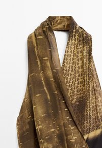 Écharpe marron avec un motif texturé, mélange de teintes claires et foncées, présentant des formes organiques et des designs géométriques. Tissu doux.