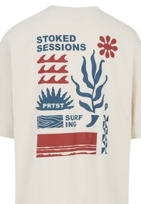 Krémové tričko s grafickými motivy v červené a modré barvě, včetně vln, rostlin a textu "STOKED SESSIONS" a "PRST SURFING."
