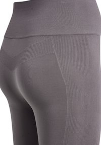 Grå leggings lavet af elastisk stof, med høj talje og ribbet tekstur med et chevronmønster på siderne.