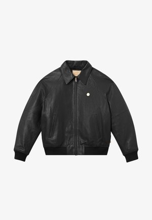 Chaqueta de cuero negra con cierre frontal, puños y dobladillo acanalados, dos bolsillos laterales y cuello. Presenta un pequeño logo metálico en el pecho.