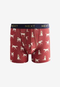 Rote Boxershorts mit einem sich wiederholenden Muster von weißen Hunden, mit einem marineblauen elastischen Bund, auf dem "NEXT" eingraviert ist. Weicher, dehnbarer Stoff.