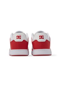 Zapatillas rojas y blancas con una parte superior de cuero suave, suela de goma blanca y logo de DC en rojo en el talón. Punta redondeada y cuello acolchado.