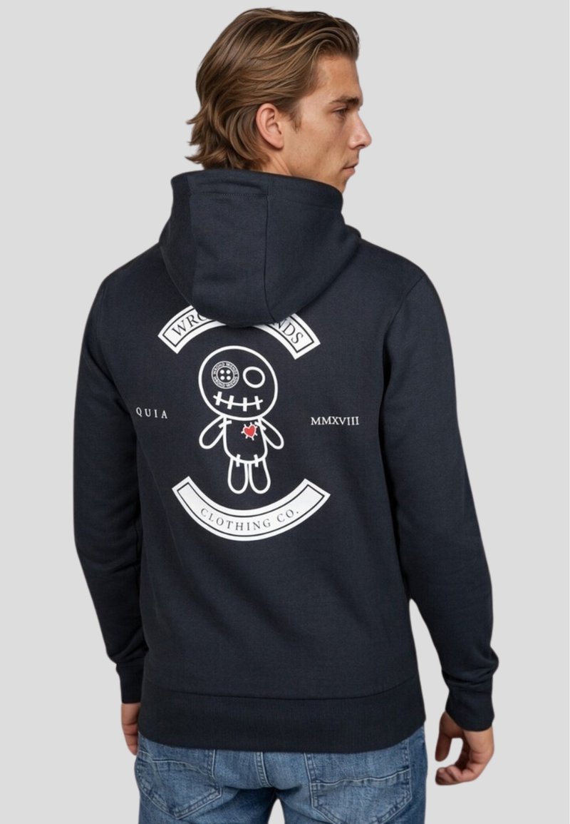 Sudadera de marina hecha de una mezcla de algodón. Presenta un gráfico en la parte espalda de una muñeca con ojos de botón y boca bordada, acentuada con texto blanco y un corazón.