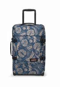 Mochila azul con ruedas con un patrón de hojas tropicales, detalles y herrajes negros, dos correas laterales de compresión, asa superior y asa retráctil.