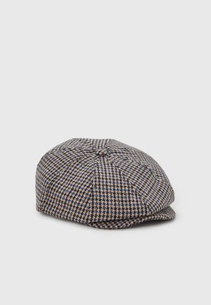 Casquette plate à motif pied-de-poule marron, beige et bleu, avec un petit bouton sur le dessus et une courte visière à l'avant.