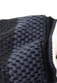 Knitted blanket featuring a textured pattern in shades of black and gray, with a smooth white border and a soft, fuzzy surface.