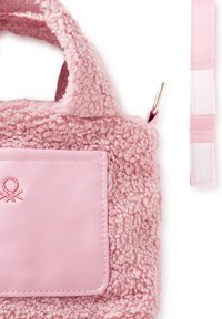 Růžová kabelka z texturovaného, načechraného materiálu s hladkým růžovým koženým kapsou, která má malý vyšívaný motiv a odnímatelný popruh.