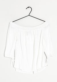 Blusa bianca off-the-shoulder con maniche a tre quarti. Presenta un colletto smock e dettagli con fiocchi ai polsini delle maniche. Tessuto dalla texture liscia.