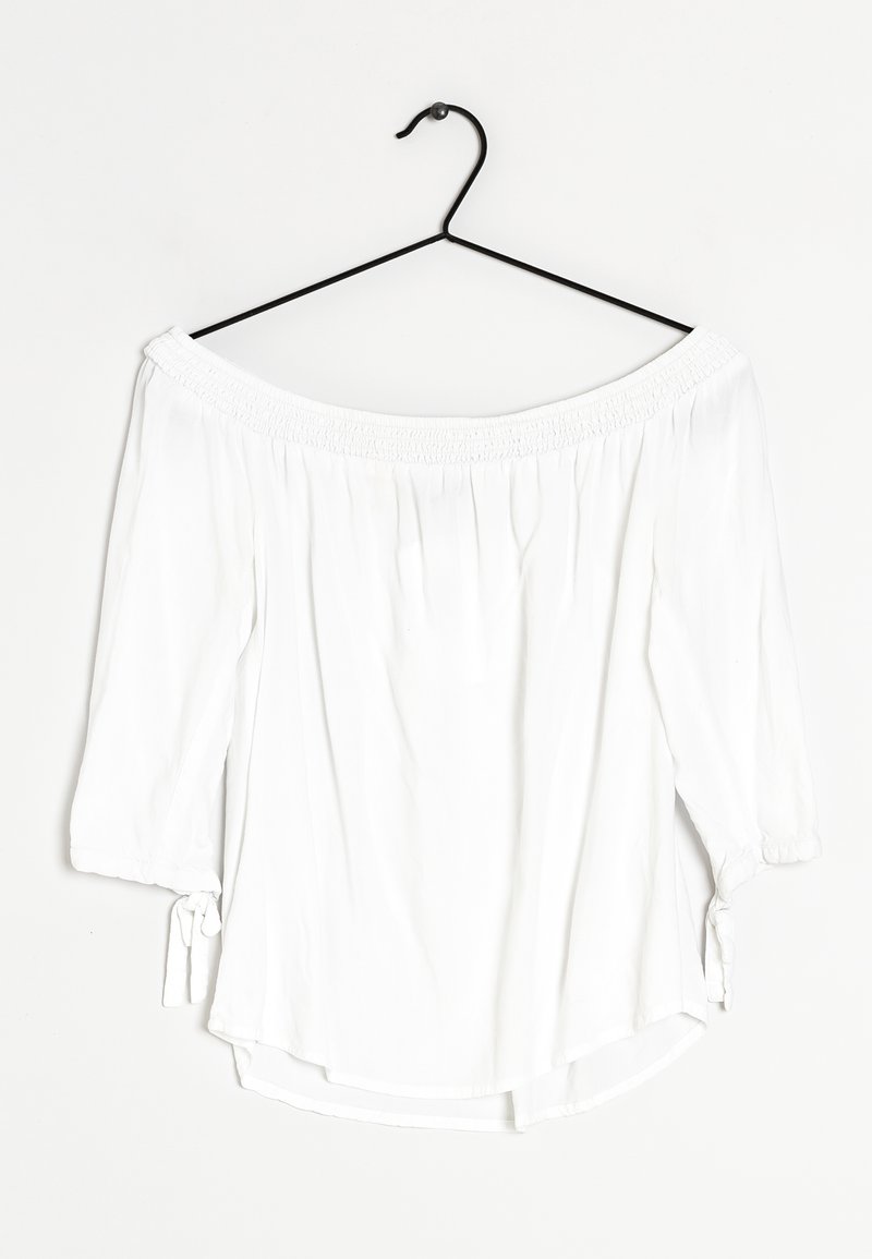 Weiße schulterfreie Bluse mit Dreiviertelärmeln. Mit gerafftem Ausschnitt und Bindedetails an den Ärmelbündchen. Glatte Stoffstruktur.