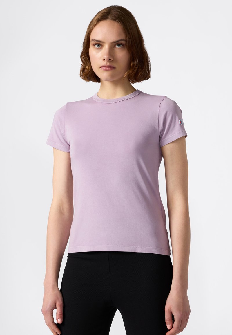 Jasnofioletowy T-shirt z krótkim rękawem, wykonany z miękkiego materiału, z okrągłym dekoltem i akcentem logo na lewym rękawie. Prosty, dopasowany krój.