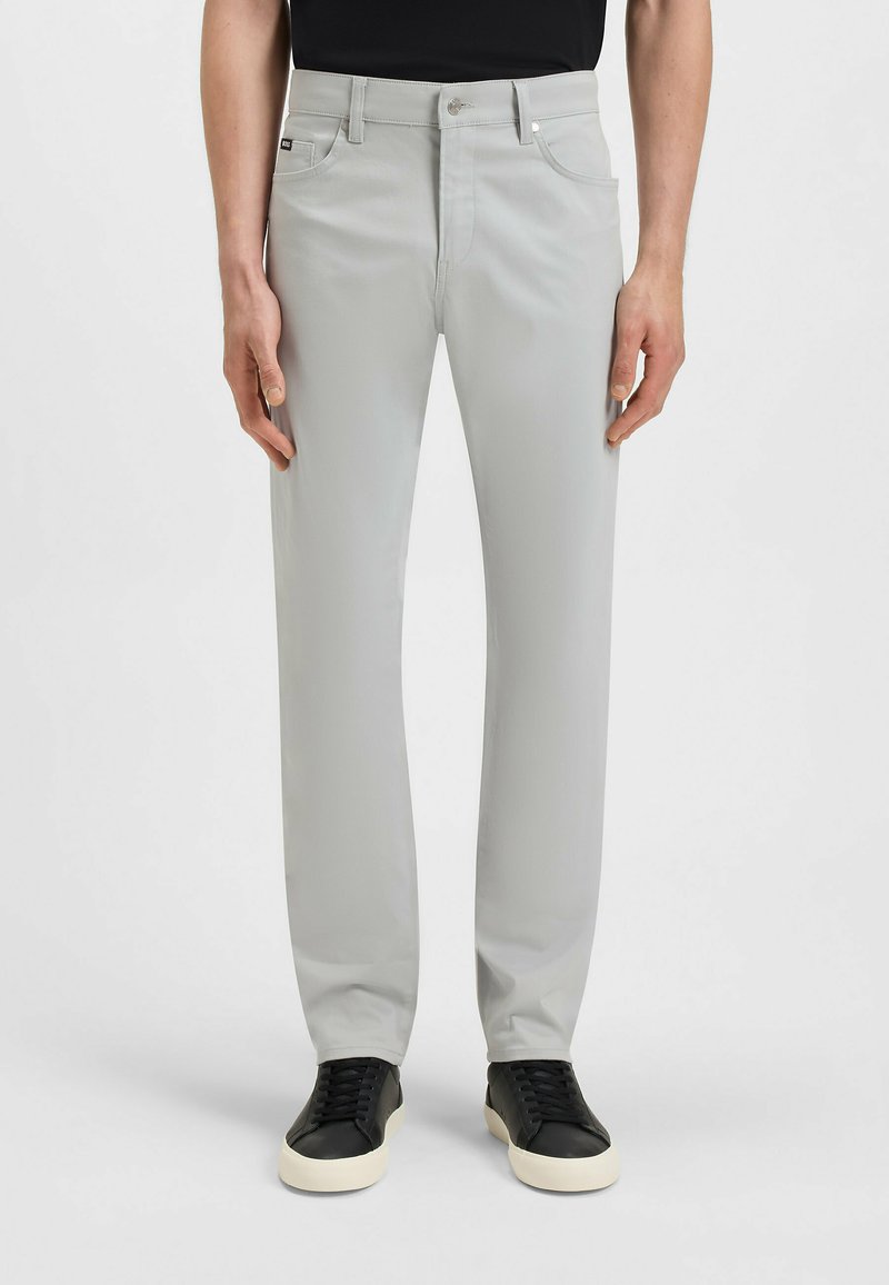 Jasnoszare spodnie o prostych nogawkach wykonane z gładkiej tkaniny, z klasycznym pięciokieszeniowym wzorem, metalowym guzikiem i delikatnym stretch.