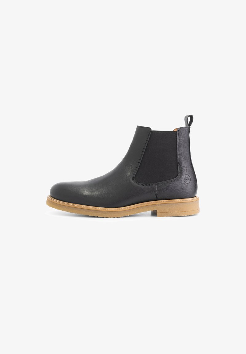 Zwarte leren Chelsea-boot met elastische zijkanten, een gestructureerde afwerking en een tan rubberen zool. Voorzien van een trekhaak aan de achterkant.