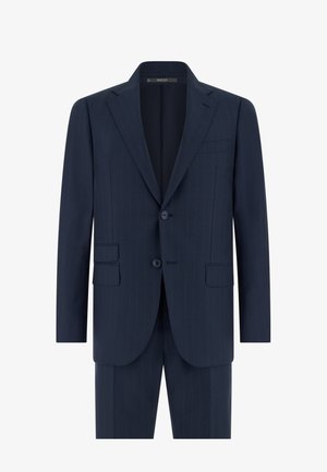 Donkerblauw krijtstreep colbert met inkepingrevers, twee voorste knopen, klepzakken en bijpassende broek zichtbaar aan de onderkant.