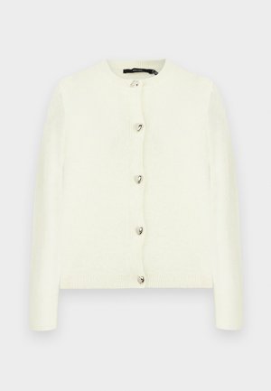 Valge pehme materjaliga kardigan, millel on ümara kaelusega kujundus, ees kuus hõbedast südamekujulist nööpi ja soonikkoes mansetid.